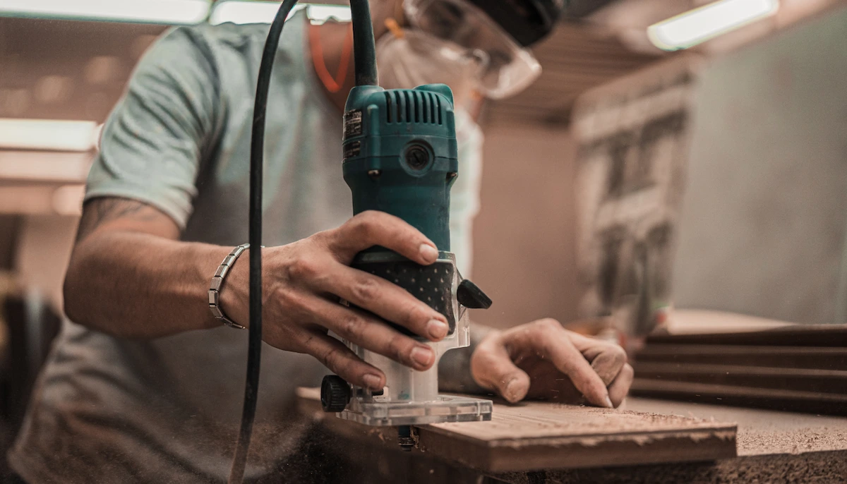 Person Holding Green and Black Power Tool - How to Choose a Reliable Renovation Contractor in Singapore