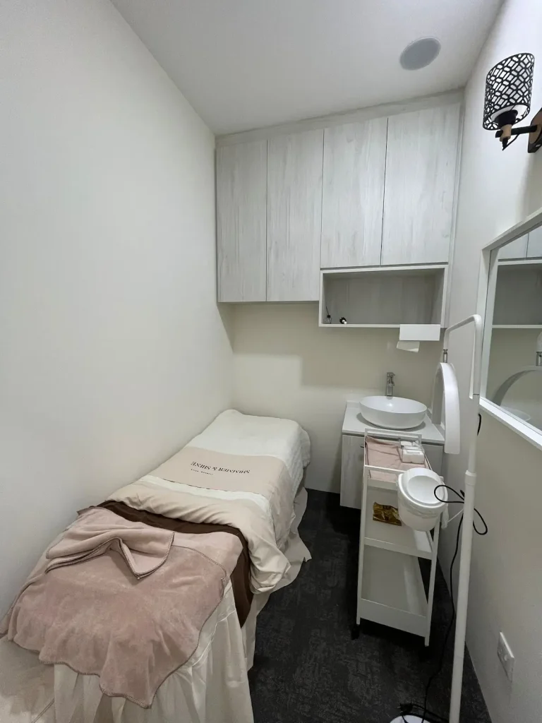 Beauty salon renovation Sengkang – treatment room with overhead cabinetry and vanity