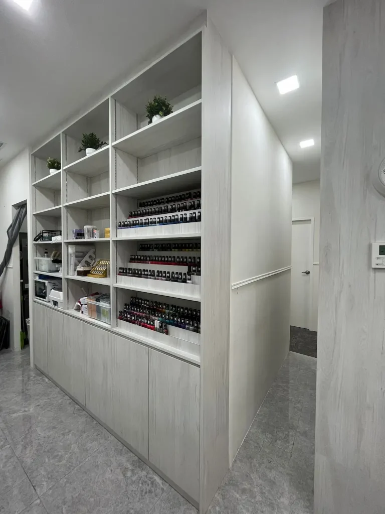 Beauty salon renovation Sengkang – full-height storage shelving and cabinets with tiered nail polish racks