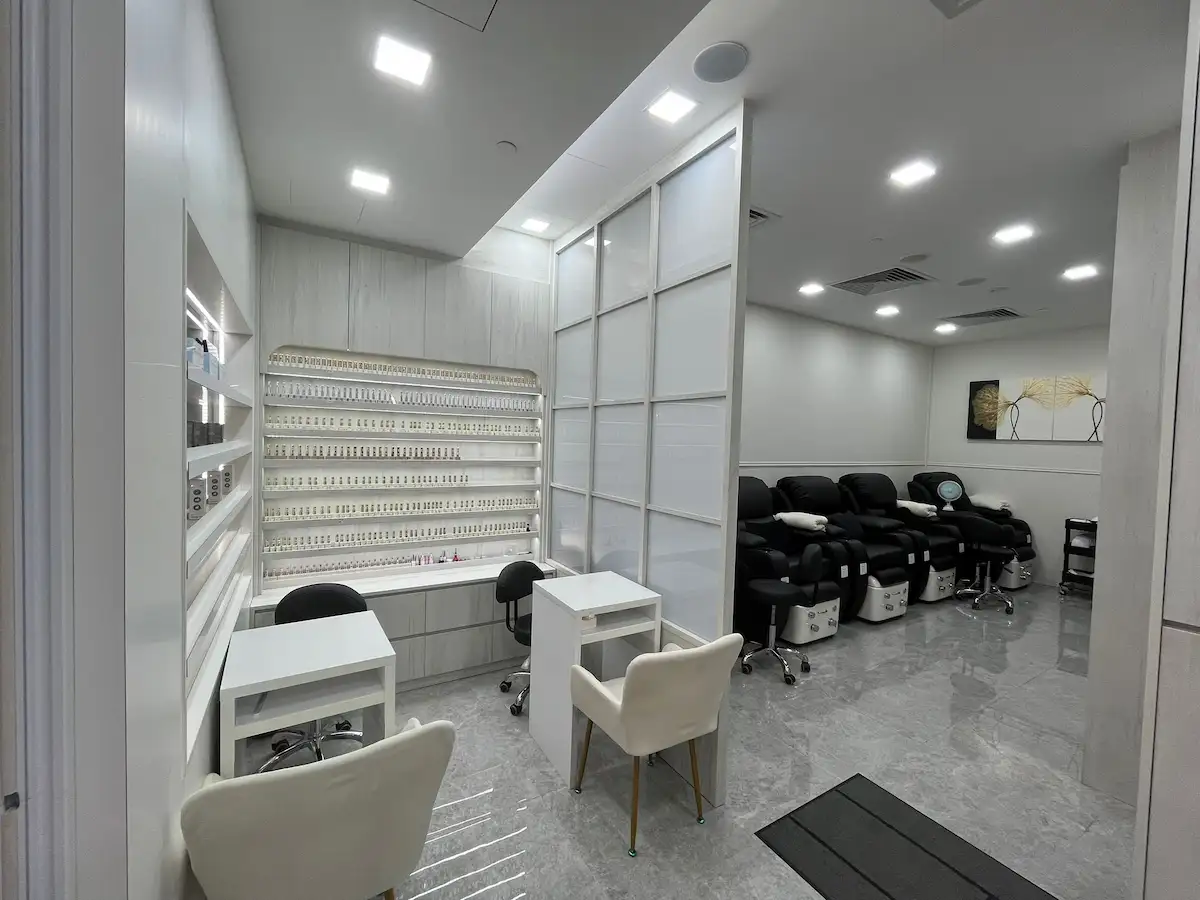 Beauty salon renovation Sengkang – manicure area with arched nail polish display wall and frosted partition