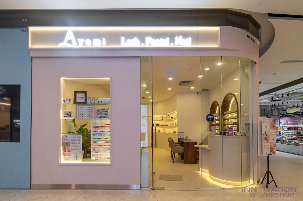 Beauty salon renovation Pasir Ris – glass frontage with illuminated signage and curved reception counter
