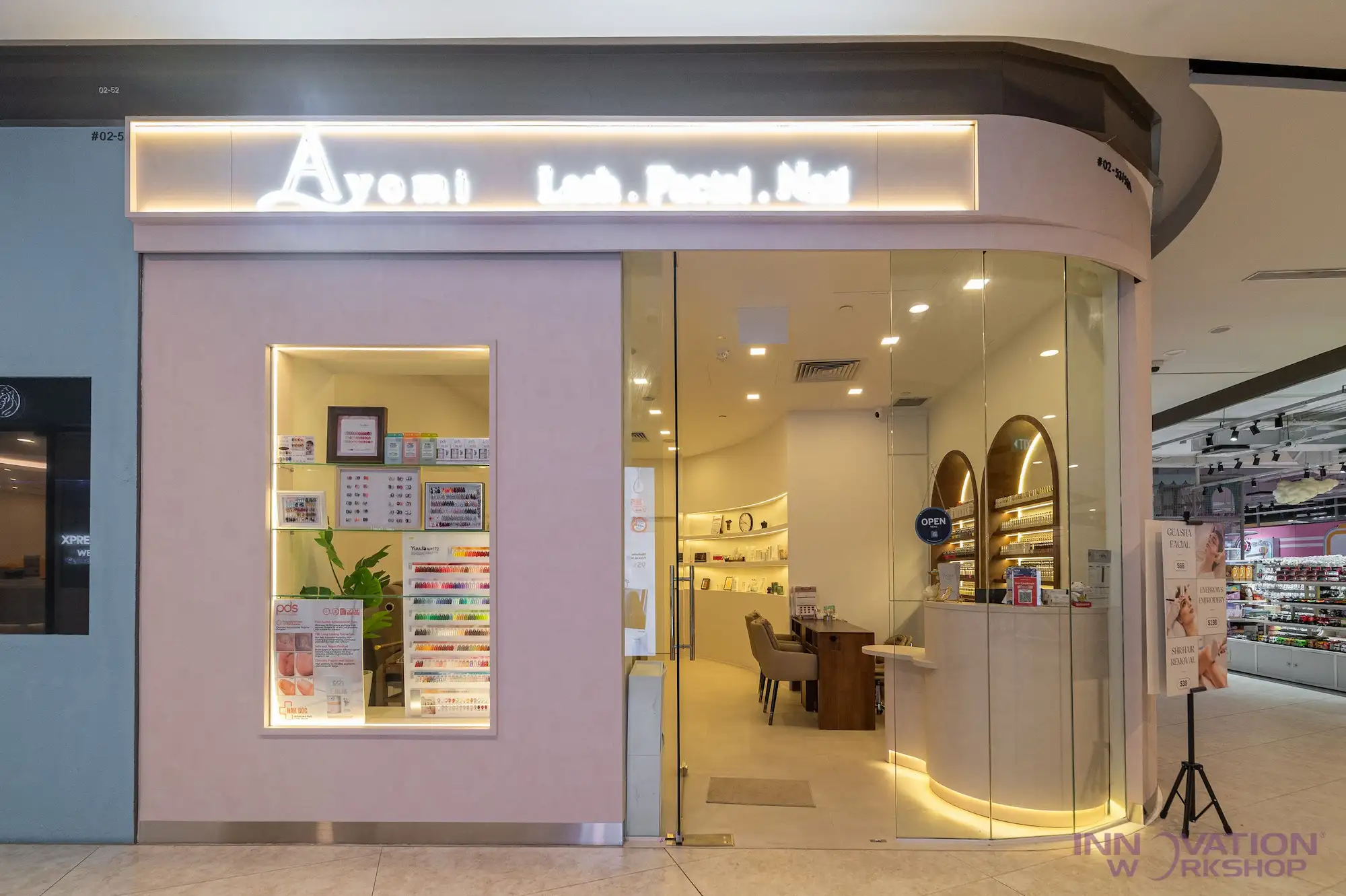 Beauty salon renovation Pasir Ris – glass frontage with illuminated signage and curved reception counter