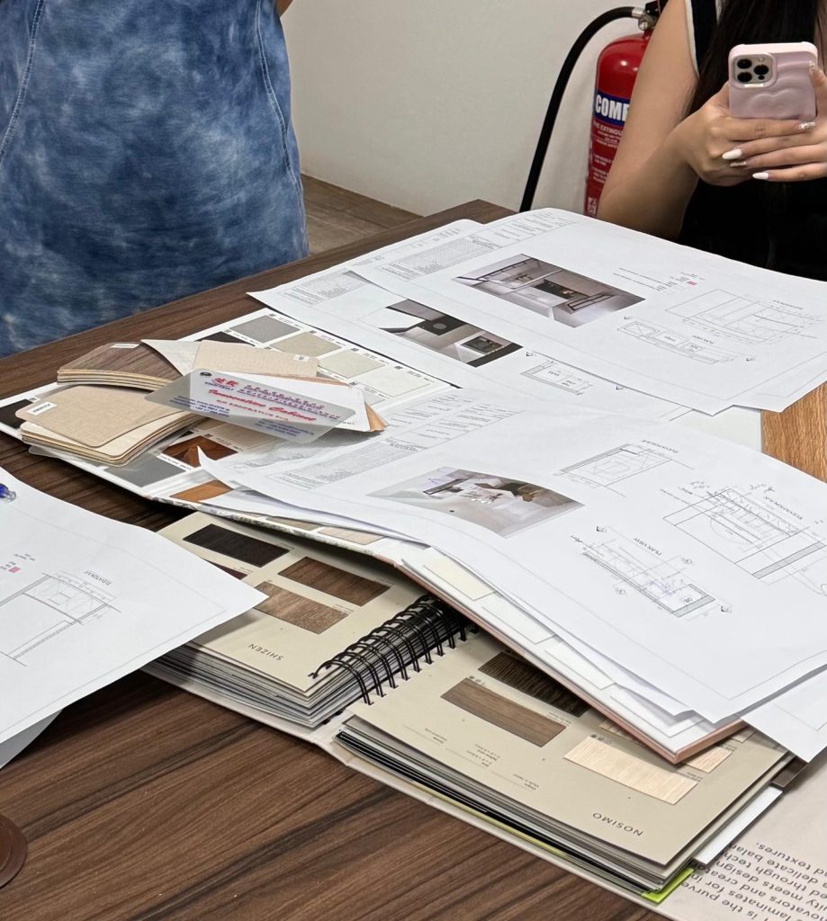 Renovation drawings, interior design renderings and laminate samples laid out for a planning discussion