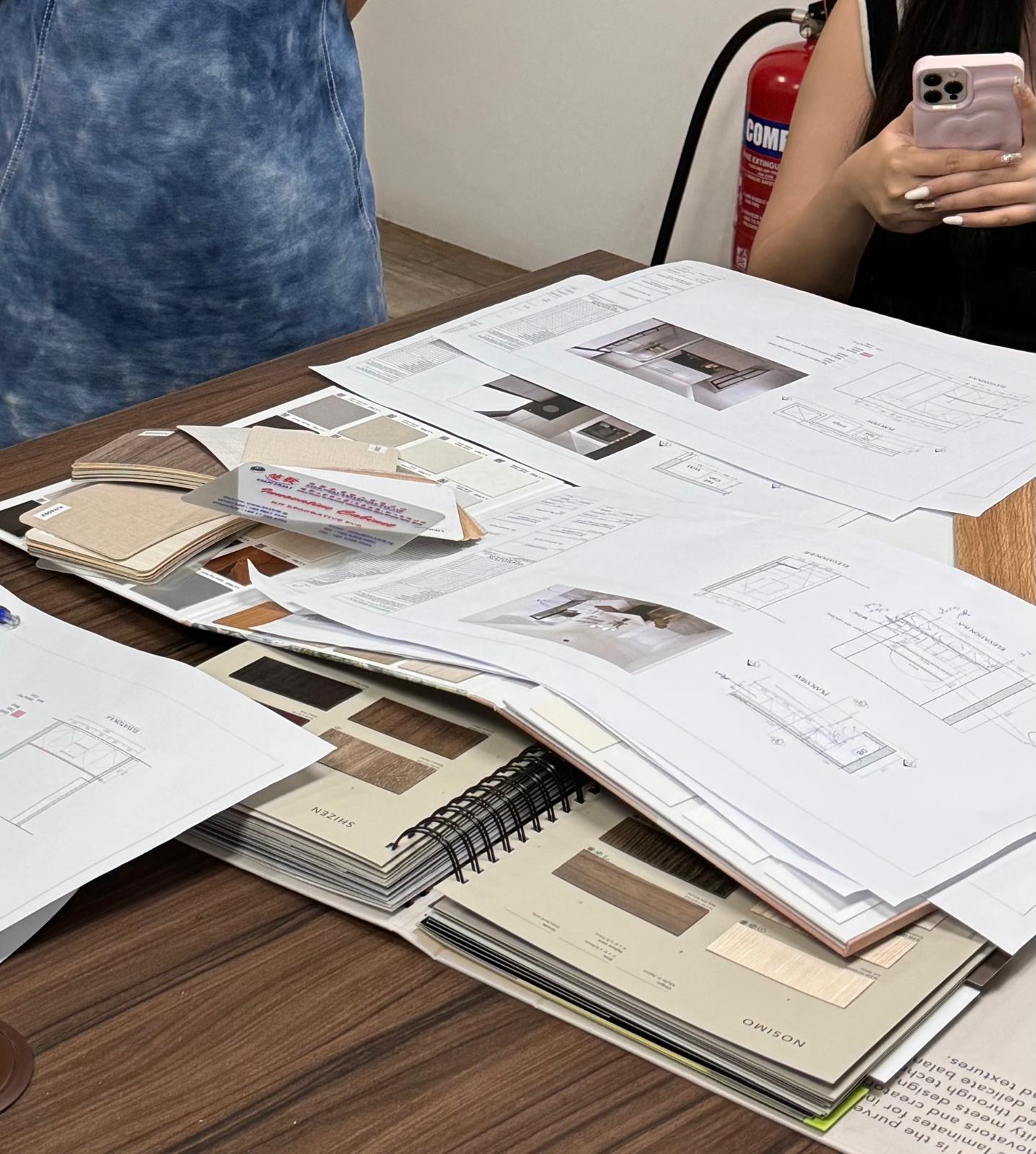 Renovation drawings, interior design renderings and laminate samples laid out for a planning discussion